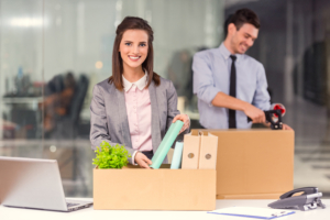 young employees following corporate relocation tips unpacking boxes and office equipment