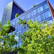 corporate building with windows and greenery around it with a blue sky