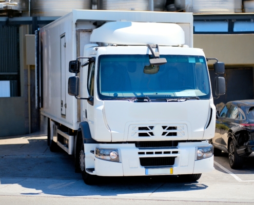 large white transfer truck with a cold temperature controlled back for cold chain logistics purposes delivering goods